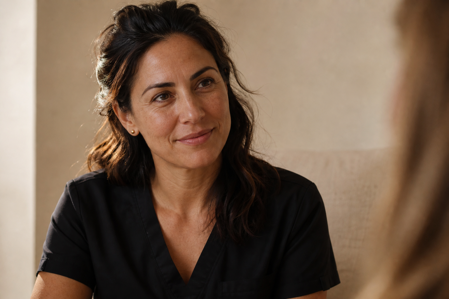 Medspa founder in a quiet consult, listening with calm focus